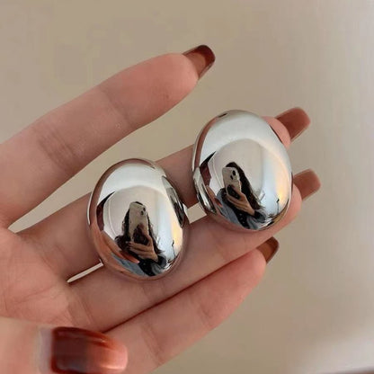 boucle d'oreille argentée dans la main