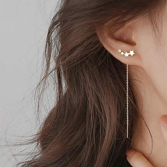 boucle d'oreille quatre étoile dorée à l'oreille droite