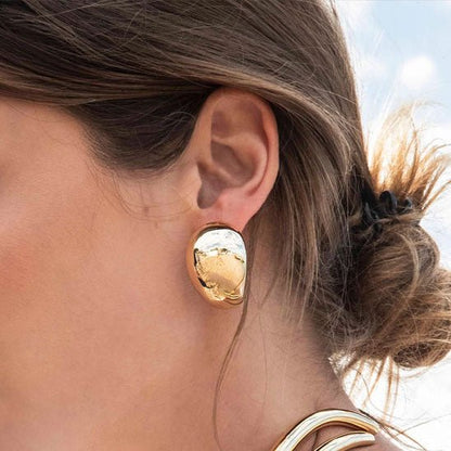 boucle d'oreille dorée sur l'oreille gauche