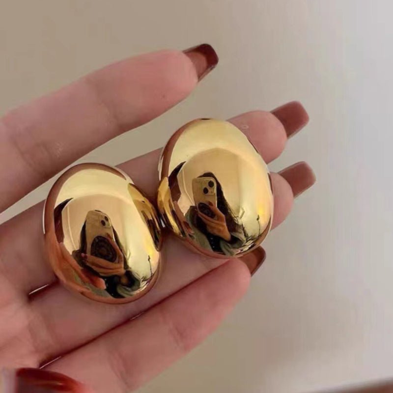 boucle d'oreille dorée dans la main