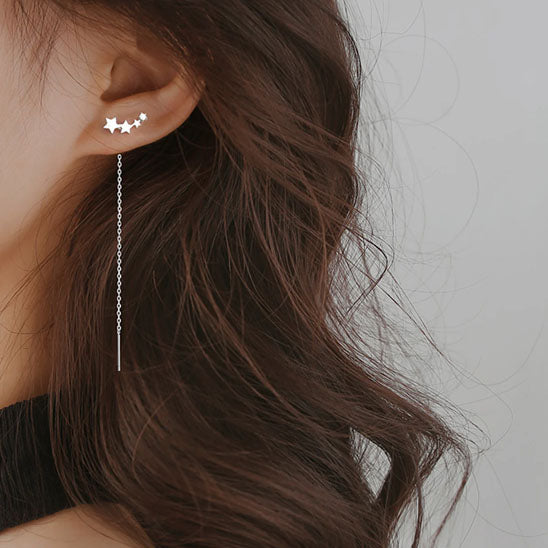 boucle d'oreille quatre étoile argentée à l'oreille gauche
