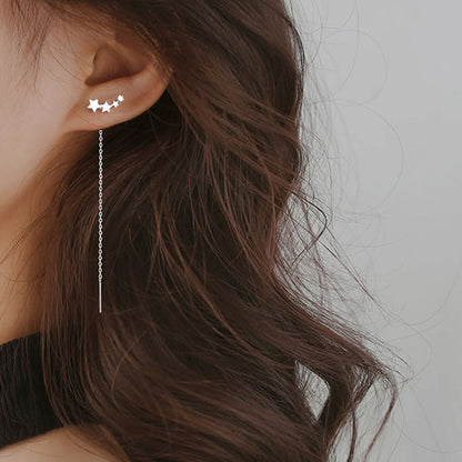 boucle d'oreille quatre étoile argentée à l'oreille gauche