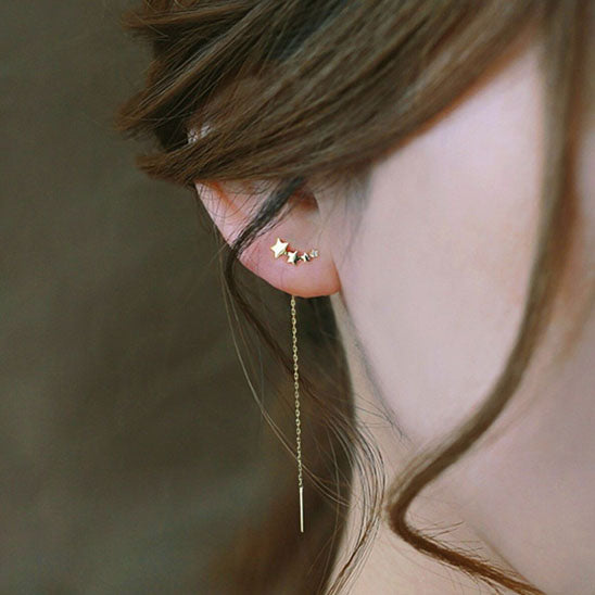 boucle d'oreille quatre étoile dorée à l'oreille droite