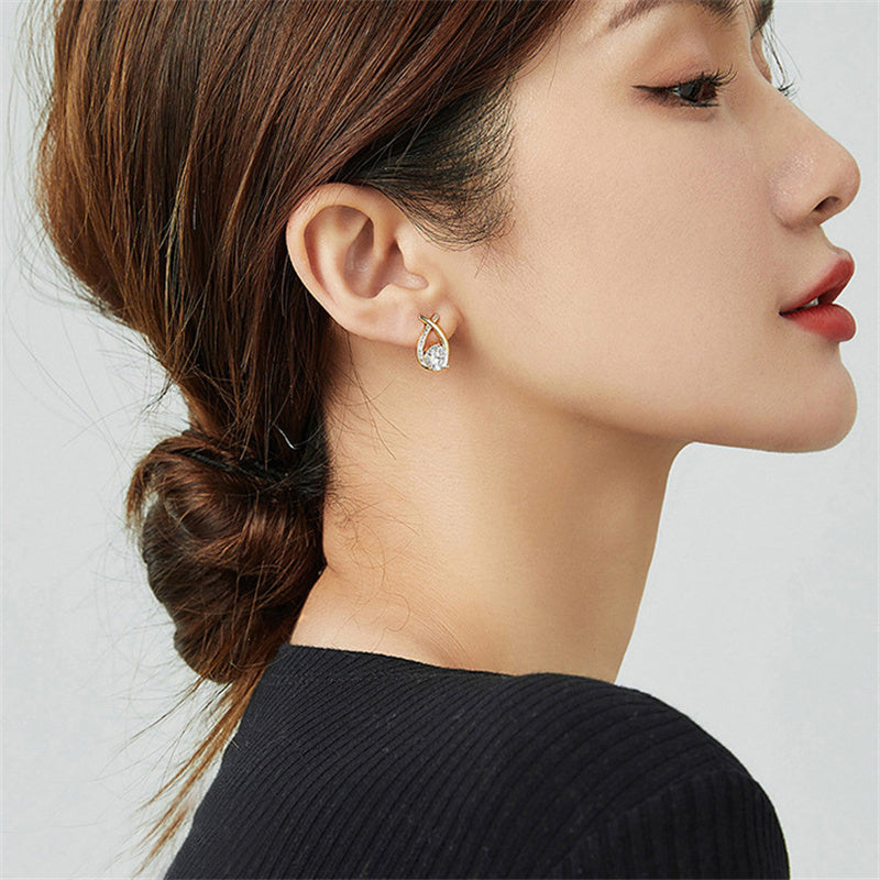 Boucles d'oreilles fantaisie Ravelys dorées  portées par une femme élégante