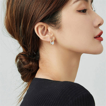 Boucles d'oreilles fantaisie Ravelys dorées  portées par une femme élégante