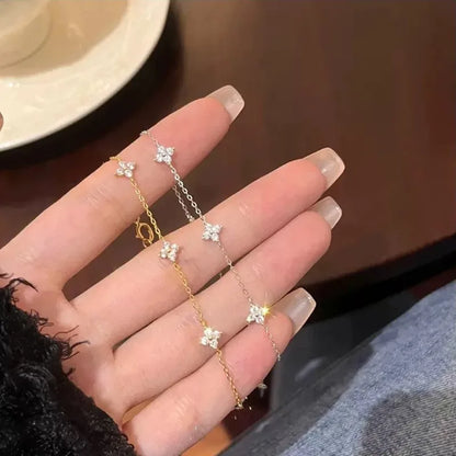 Bracelet Trèfle Lyssène argenté et doré dans la main