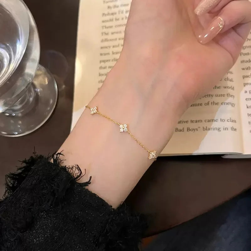Bracelet Trèfle Lyssène doré au poignet gauche