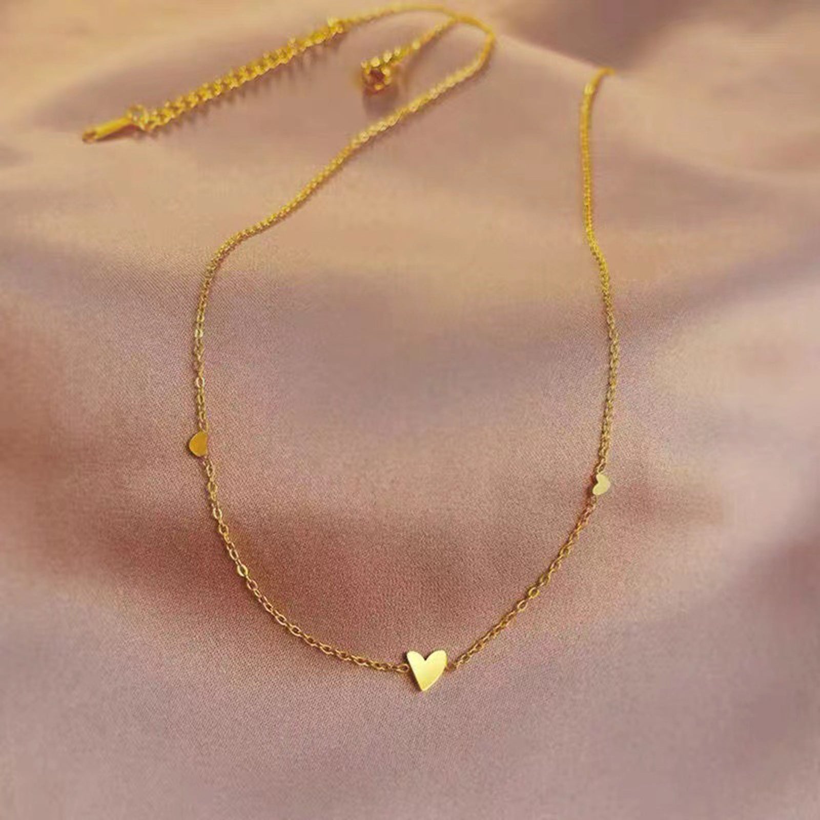 Collier cœur solvera or déposé sur fond rose