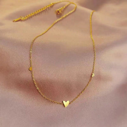 Collier cœur solvera or déposé sur fond rose