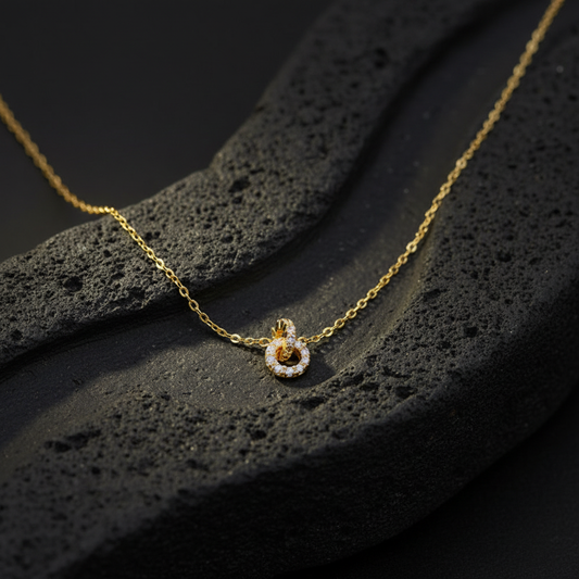 Collier ras de cou Mileora doré posé sur une pierre