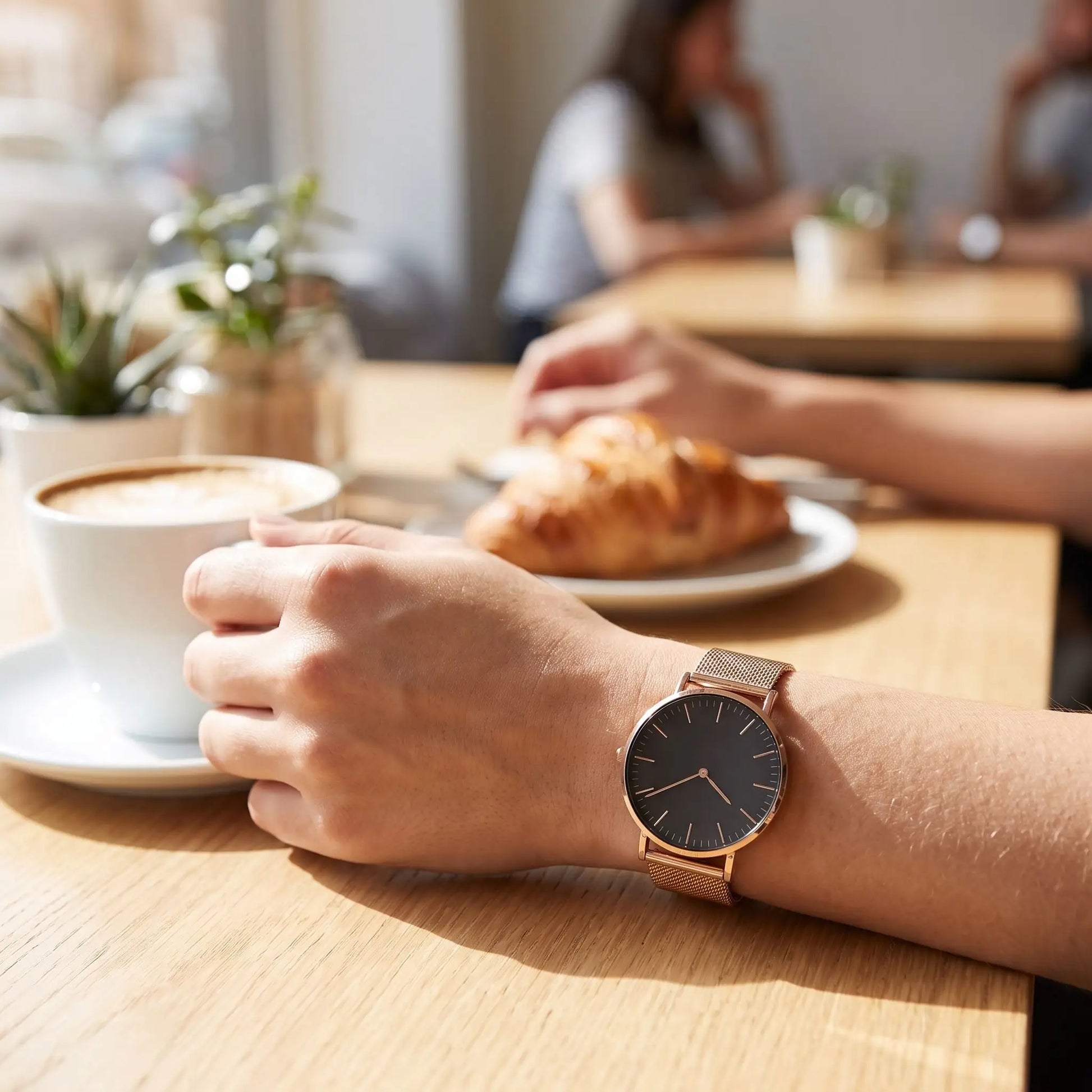 Montre femme tendance Orensya noir femme dans un café