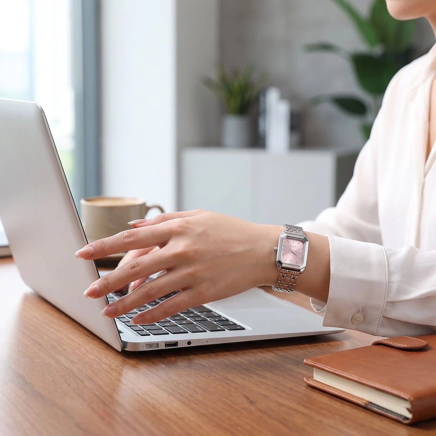 Montre rectangulaire femme oripse argent rose poudré portée par une femme sur son ordinateur au travail